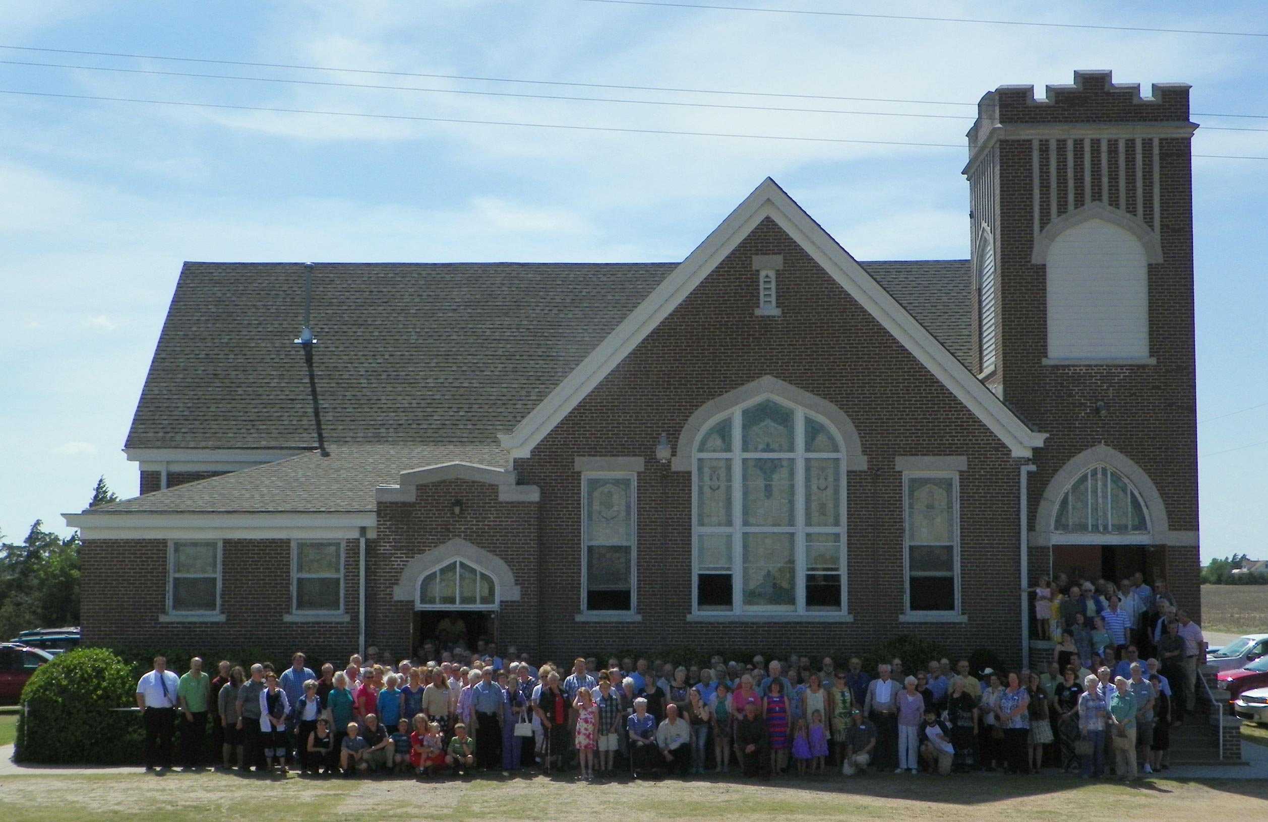 People who attended the memorial celebration of the Bergthal Mennonite Church on May 26, 2013, stood for a photo afterward. The photo was made by Sandy Unruh, the wife of Steve Unruh, who grew up in the church. Photo copyright 2013 by Sandy Unruh.