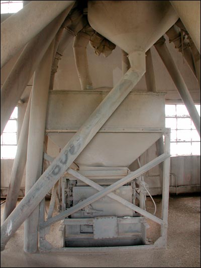 This headhouse device, coated with grain dust, spreads grain among the Farmers Grain bins after the grain has been lifted from the trough into which trucks pour it. Photo copyright 2005 by Leon Unruh.