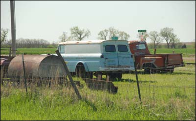 Rear view of two trucks for sale in a lot in southwestern Pawnee Rock. Photo copyright by Jim Dye.