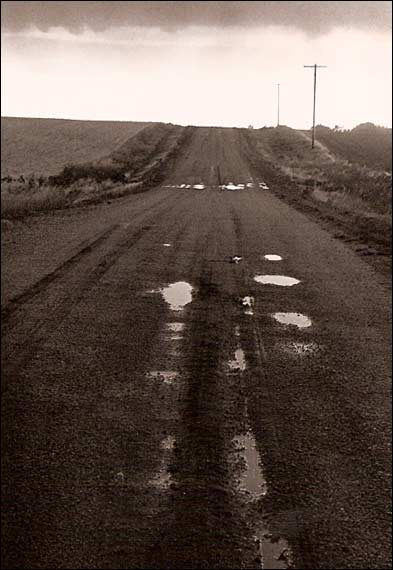 The rain-soaked road just east of the Paul Schmidt farm, mid-1970s. Photo copyright 2007 by Leon Unruh.