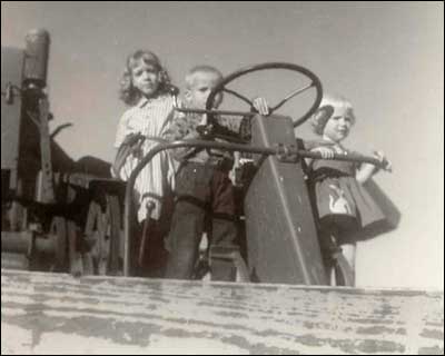 Mary Fox, Leon Unruh and Cheryl Unruh on Otis Unruh's combine, about 1962.