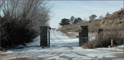 The lilacs, gate, and Santa Fe Trail marker at the entrance to Pawnee Rock State Park. Photo copyright 2005 by Leon Unruh.