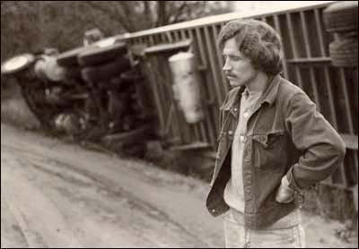Truck driver and his rolled-over 18-wheeler in Pawnee Rock, about 1975. Copyright Leon Unruh.