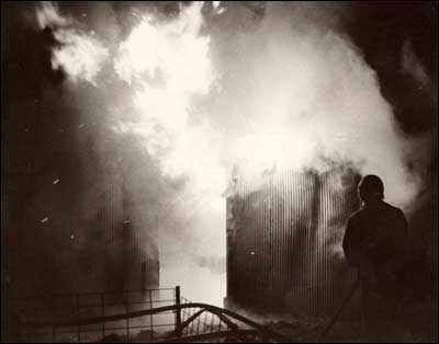 The hog shed on the Dale and Linda Slavic burns in the 1970s as the Pawnee Rock fire department tries to put out the blaze. Photo copyright Leon Unruh.