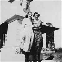 Two women on Pawnee Rock by the monument in the 1920s or 1930s.